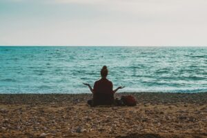 person doing yoga on seashore during daytime