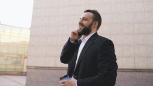 Man in suit talking on phone holding coffee cup