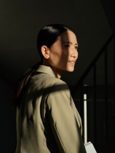 Woman in a blazer with sunlight on her face.