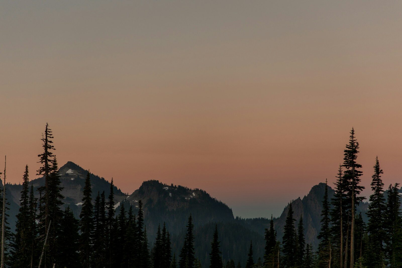 Mountain peaks silhouetted against a dusky sky