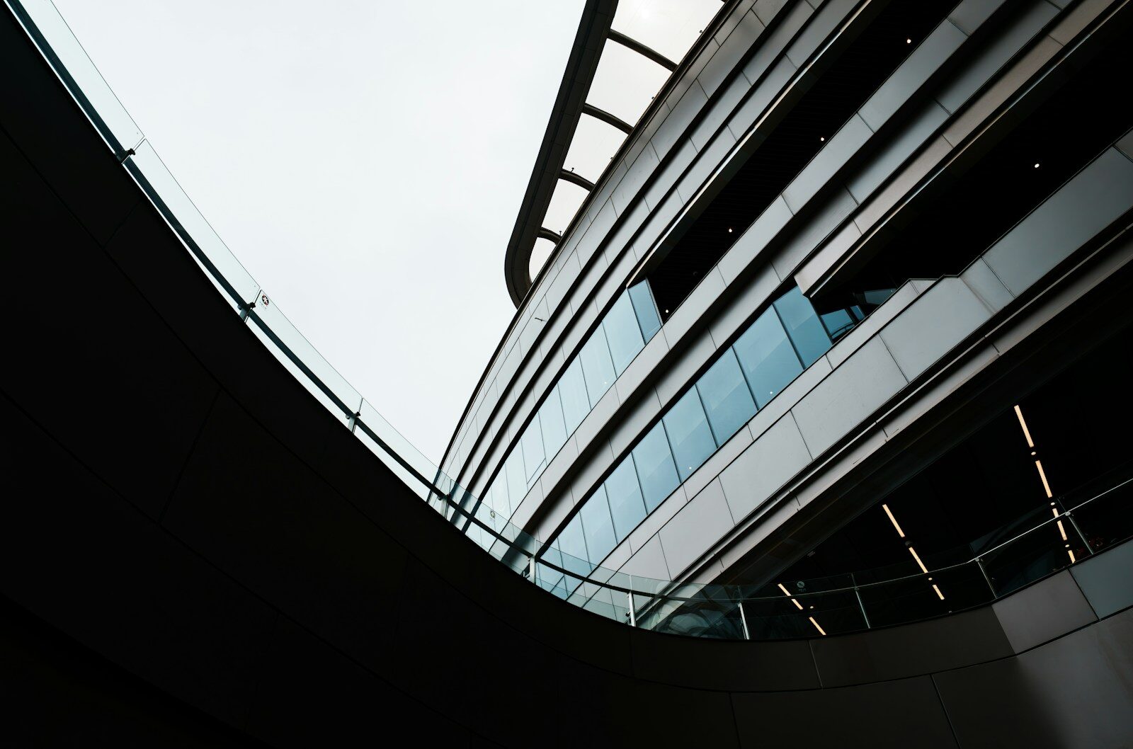 Curved modern building with glass facade and escalators