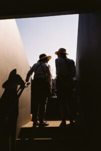 Two straw-hatted stewards silhouetted at gangway exit