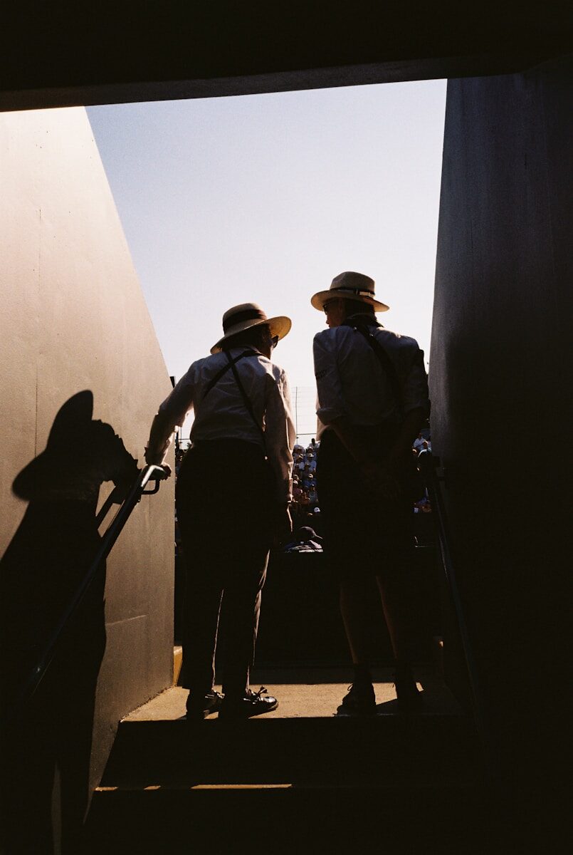 Two straw-hatted stewards silhouetted at gangway exit